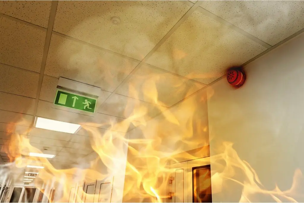 Large fire spreading through commercial building hallway toward ceiling