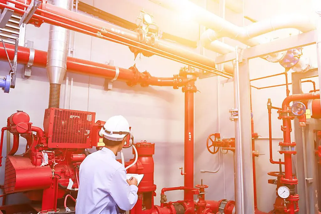 Technician performing commercial fire sprinkler system inspection and maintenance